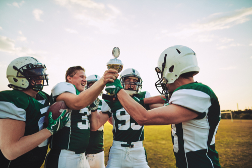 Athletes celebrate a win on artificial turf football field